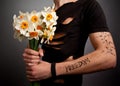 Young man in modern black clothing holding bouquet of narcissus Royalty Free Stock Photo