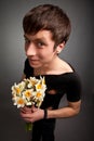 Young man in modern black clothing holding bouquet of narcissus Royalty Free Stock Photo