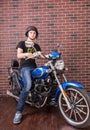 Young Man on Motorcycle in front of Brick Wall Royalty Free Stock Photo