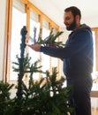 Young man mounting artificial Christmas tree Royalty Free Stock Photo