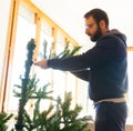 Young man mounting artificial Christmas tree Royalty Free Stock Photo