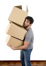 Young man moving in a new house carrying pile of cardboard boxes Royalty Free Stock Photo