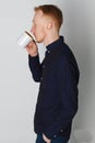 A young man with a mug of tea or coffee. He pleased. White background. Redhead male with white mug. Royalty Free Stock Photo