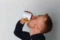 A young man with a mug of tea or coffee. He pleased. White background. Redhead male with white mug. Royalty Free Stock Photo