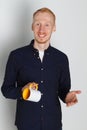 A young man with a mug of tea or coffee. He pleased. White background. Redhead male with white mug. Royalty Free Stock Photo