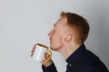 A young man with a mug of tea or coffee. He pleased. White background. Redhead male with white mug. Royalty Free Stock Photo