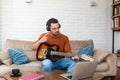 Young man music teacher giving guitar lessons to students online on laptop computer from home. Learning to play electric guitar Royalty Free Stock Photo