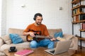 Young man music teacher giving guitar lessons to students online on laptop computer from home. Learning to play electric guitar Royalty Free Stock Photo