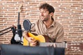 Young man musician singing song playing classical guitar at music studio Royalty Free Stock Photo