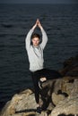 Young man in a Namaste greeting position while freeing his mind from worries in tree pose Royalty Free Stock Photo