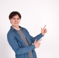 Young man nerd pointing finger aside at blank copy space, isolated on white grey studio background Royalty Free Stock Photo