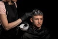 Young man with new haircut. Professional hairstyle. Model and trendy hairdressed. Barber is coloring male hair. Handsome guy in Royalty Free Stock Photo