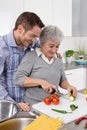 Young man and older woman cooking together in the kitchen. Royalty Free Stock Photo
