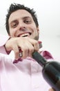 Young man opening a bottle of red wine Royalty Free Stock Photo