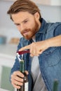 young man opening bottle wine at home Royalty Free Stock Photo