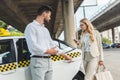 young man opening door of taxi to beautiful woman in eyeglasses