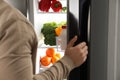 Young man opening refrigerator at home Royalty Free Stock Photo