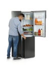 Young man opening refrigerator on white background Royalty Free Stock Photo