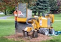 Man operates a stump grinder in a yard Royalty Free Stock Photo