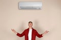 Young man operating air conditioner Royalty Free Stock Photo