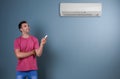Young man operating air conditioner Royalty Free Stock Photo