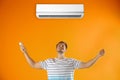 Young man operating air conditioner Royalty Free Stock Photo