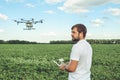 Young man operating of flying drone octocopter at the green field. Royalty Free Stock Photo