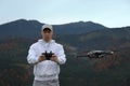 Young man operating modern drone with remote control in mountains Royalty Free Stock Photo