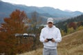 Young man operating modern drone with remote control in mountains Royalty Free Stock Photo