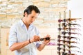 Young man at optician buying sun glasses Royalty Free Stock Photo