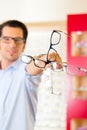 Young man at optician with glasses Royalty Free Stock Photo