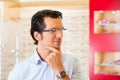 Young man at optician with glasses Royalty Free Stock Photo