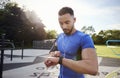 Young man at outdoor gym setting fitness app on smartwatch Royalty Free Stock Photo