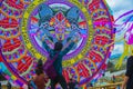 young man with outstretched hands and carrying backpack looking at giant kite