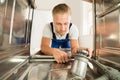 Man In Overall Repairing Dishwasher Royalty Free Stock Photo