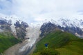 Young man overlooking amazing mountain Caucasus landscape of peaks of mountains Tetnuldi, Gistola and Dzhangi-Tau and glacier Lard