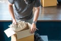 Young man packing cloth into cardboard box prepare to move out to new location