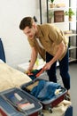 young man packing clothes into travel bag Royalty Free Stock Photo