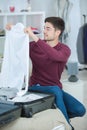 Young man packing bag and preparing for traveling Royalty Free Stock Photo