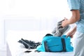 Young man packing sports stuff for training into bag in bedroom. Royalty Free Stock Photo