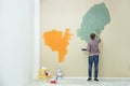 Young man painting wall indoors. Home repair Royalty Free Stock Photo