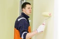 Young man is painting walls with roller Royalty Free Stock Photo