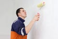 Young man is painting walls with roller Royalty Free Stock Photo