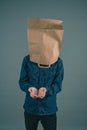 Young man with paper bag on his head, open hands for begging Royalty Free Stock Photo