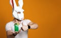 Young man in paper rabbit mask and white t-shirt drinking green cocktail drink Royalty Free Stock Photo