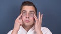 A young man with patches on his face relaxes. Spa treatments. Blue hydrogel patches for facial rejuvenation. A man is Royalty Free Stock Photo