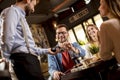 Young man paying with contactless credit card in restaurant after dinner Royalty Free Stock Photo