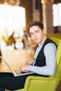 Young man with pc computer sits in a comfortable chair Royalty Free Stock Photo