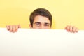 Young man peeping or looking over a white board Royalty Free Stock Photo