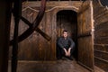 Young Man Peering Out From Cabin of Wooden Ship